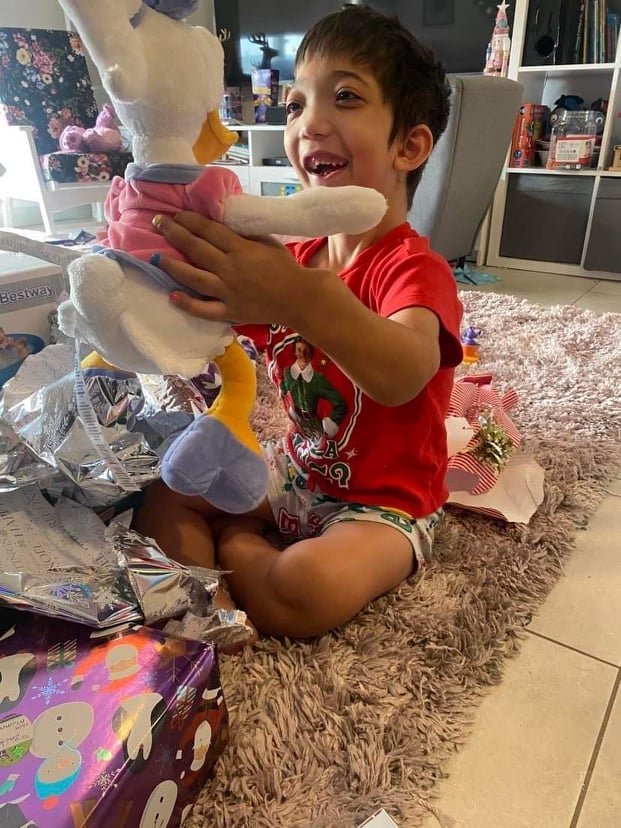 Zacky excitedly opening up his Christmas present