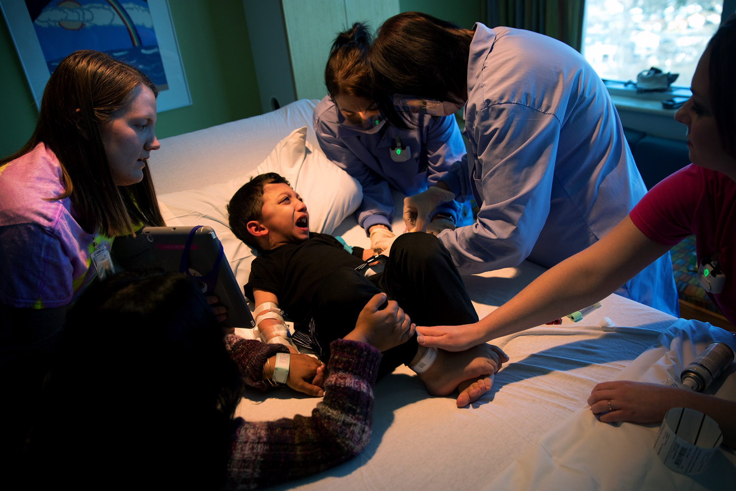 Nurses attempt to connect an IV to Arshaan's left arm before starting an infusion. Small veins that tend to burst frequently and a fear of needles make this process traumatic for the brothers.