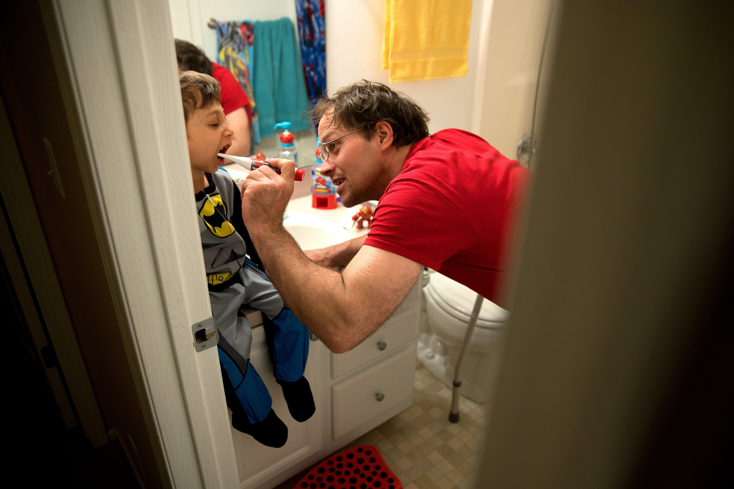 Adam Timm brushes son Jahan Adam's teeth before bedtime in March.